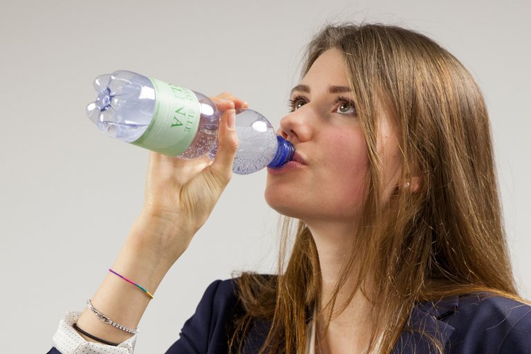 Frau trinkt aus PET-Getränkeflasche.