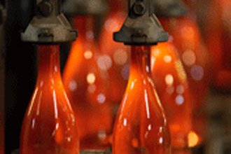 Formen der Glasflasche Aus geschmolzenem Glas werden neue Flaschen geformt.