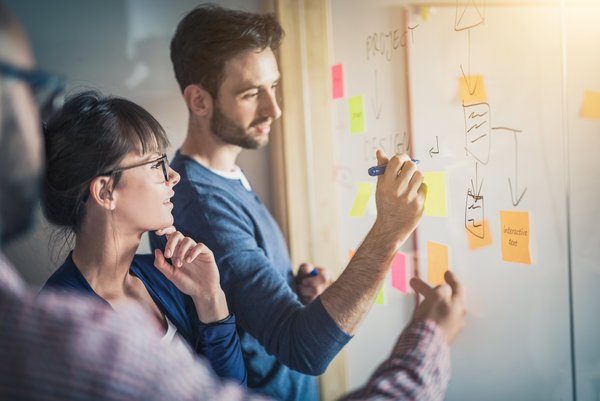 Sustainability Day und Workshops Eine junge Frau und ein junger Mann besprechen sich an einem Flipchart